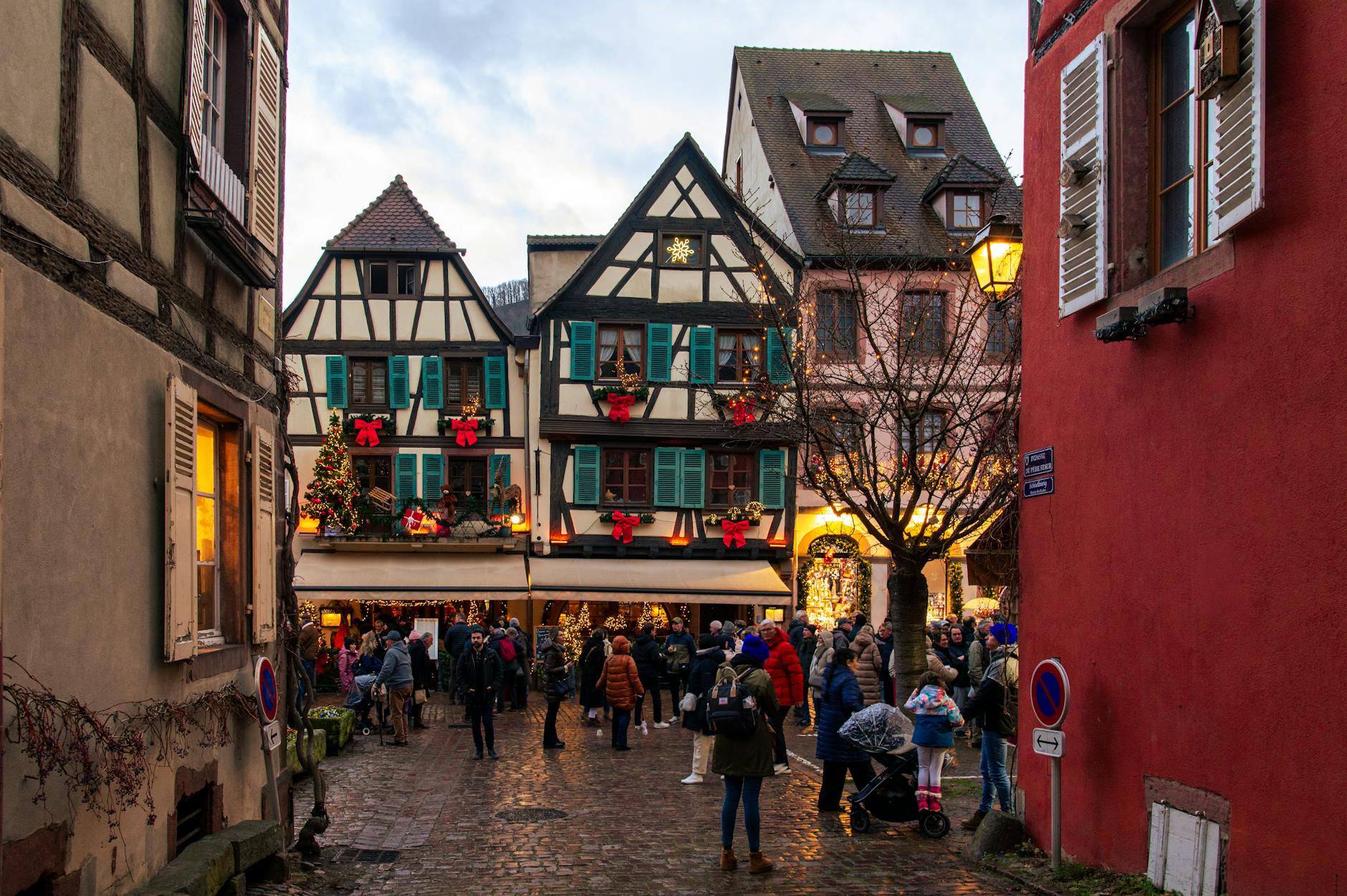 Festively decorated half-timbered houses in Colmar during Christmas market.