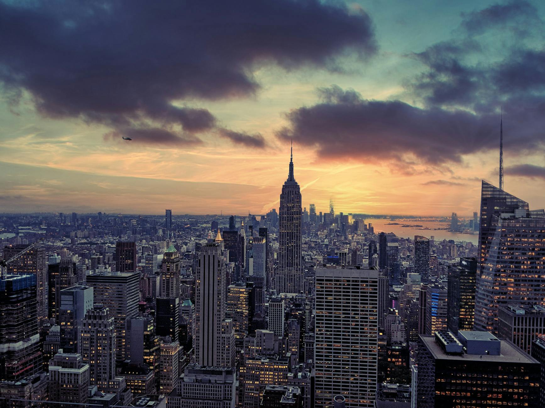 Breathtaking aerial view of New York City skyline at sunset, highlighting skyscrapers and urban architecture.