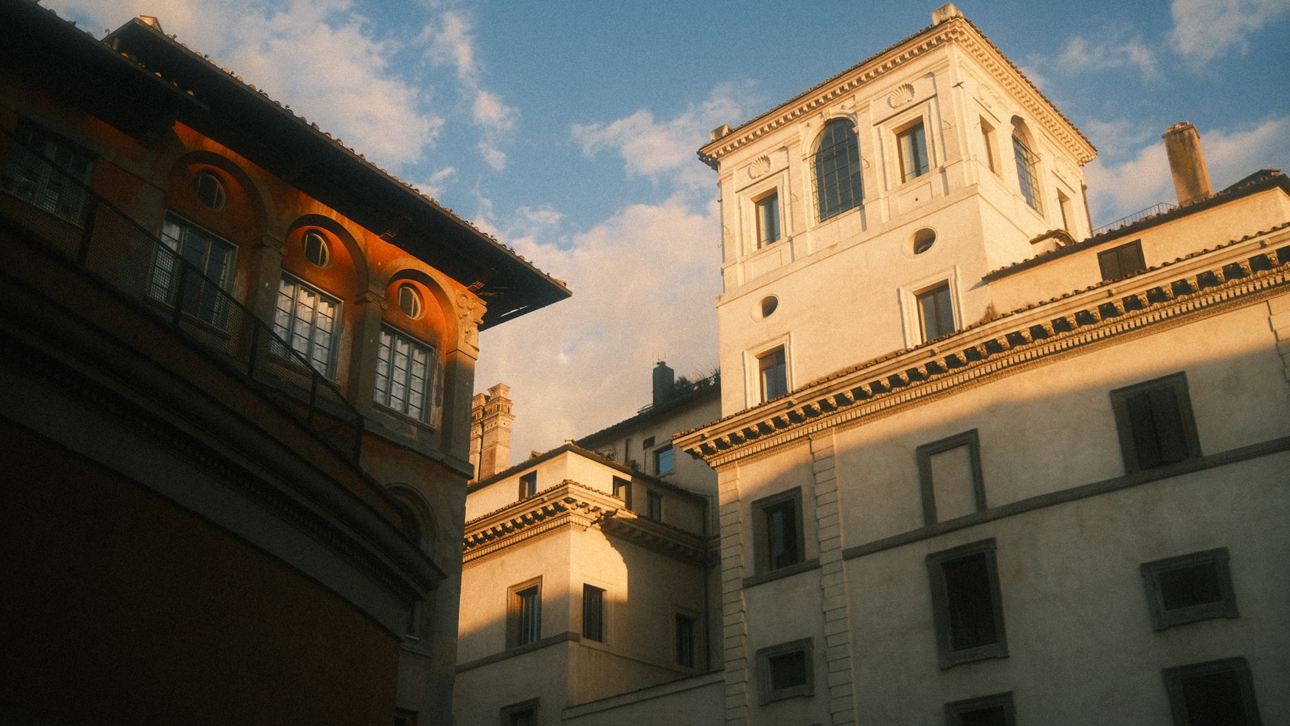 A warm natural light bathes Rome's historic architecture, showcasing classic Italian style.