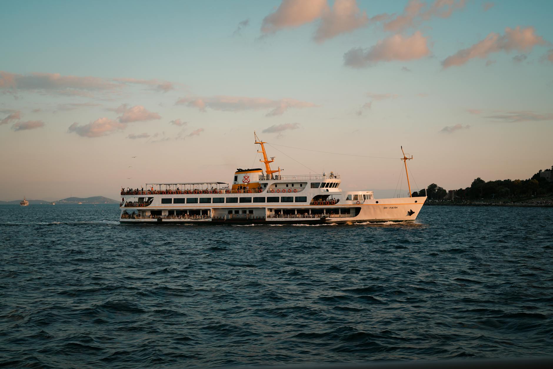 Scenic view of a passenger ferry cruising the sea during sunset, capturing tranquil ocean travel vibes.