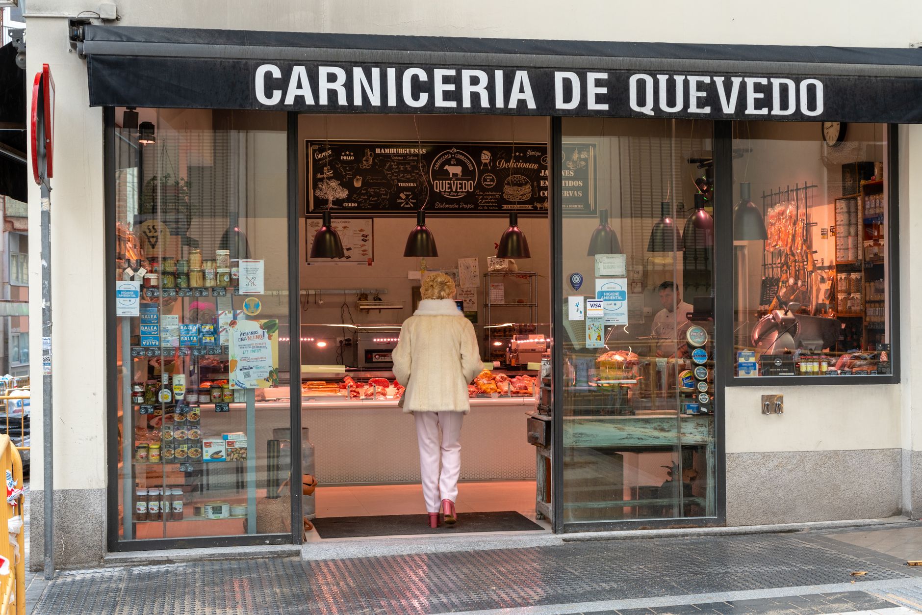Discover a cozy butcher shop in Quevedo, Madrid, showcasing a variety of meats and deli products.