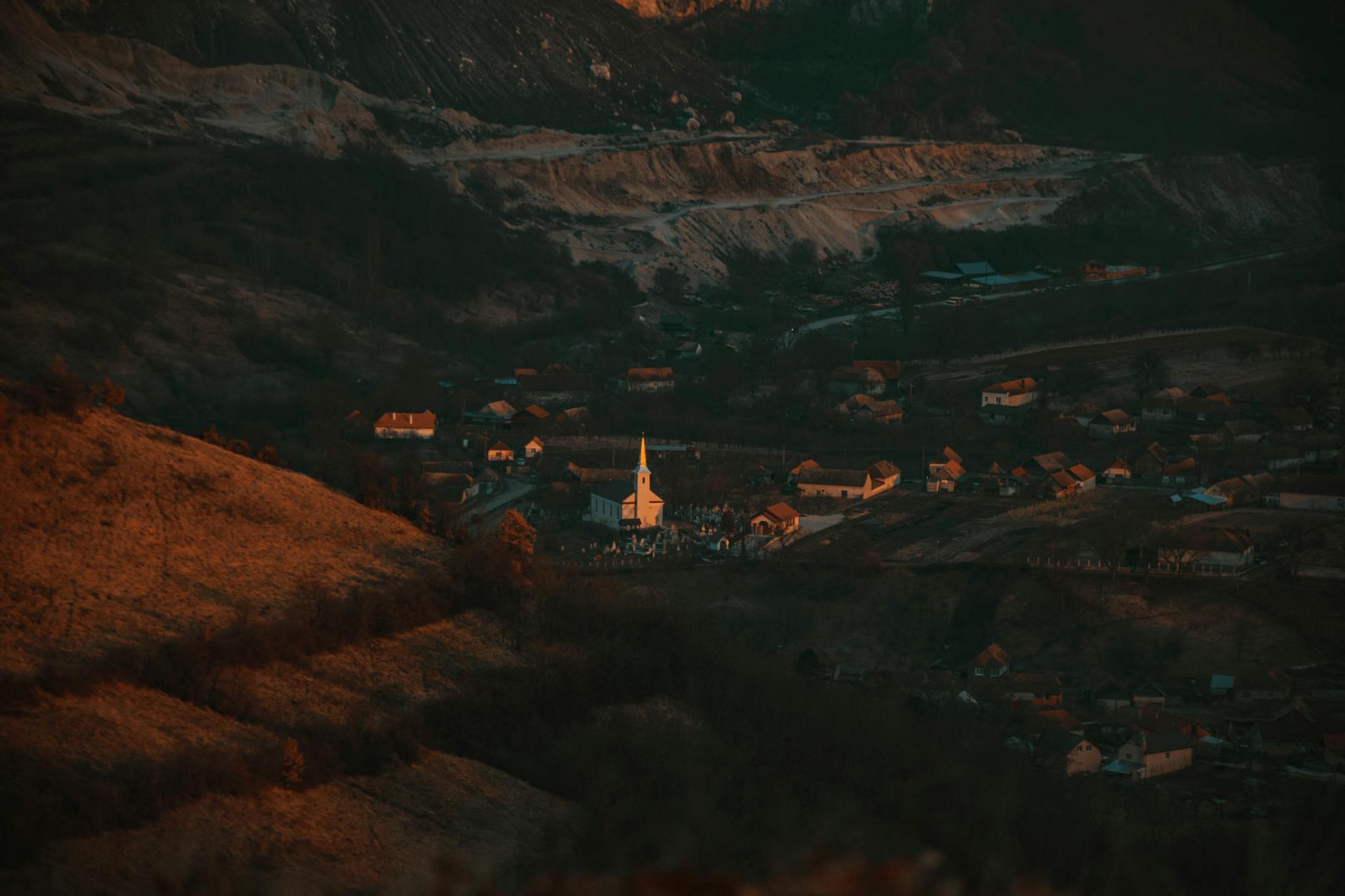 Aerial view of a church nestled in the valley of Alba Iulia, România at sunset.