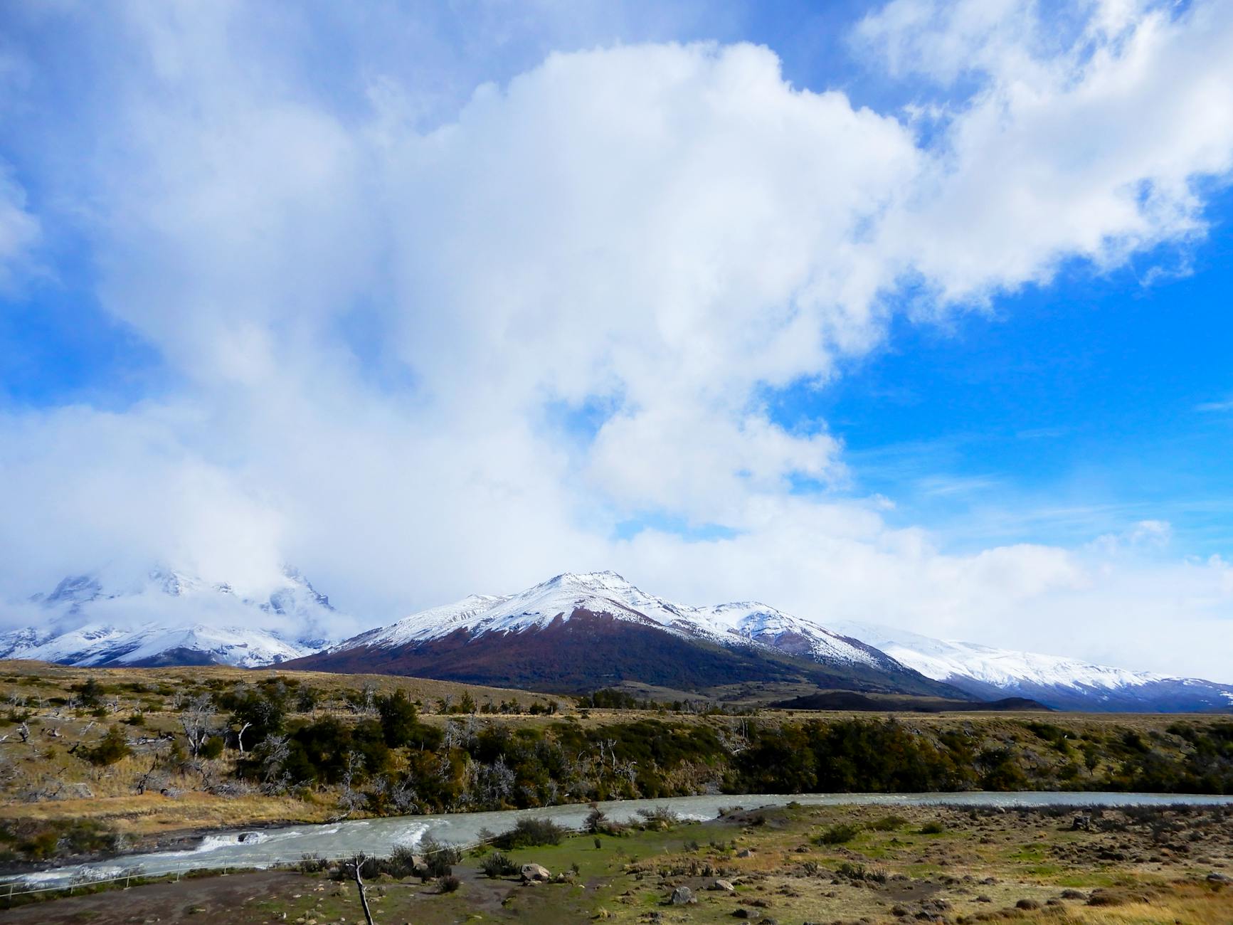 A breathtaking landscape of snow-capped mountains and a river in Torres del Paine, Chile.